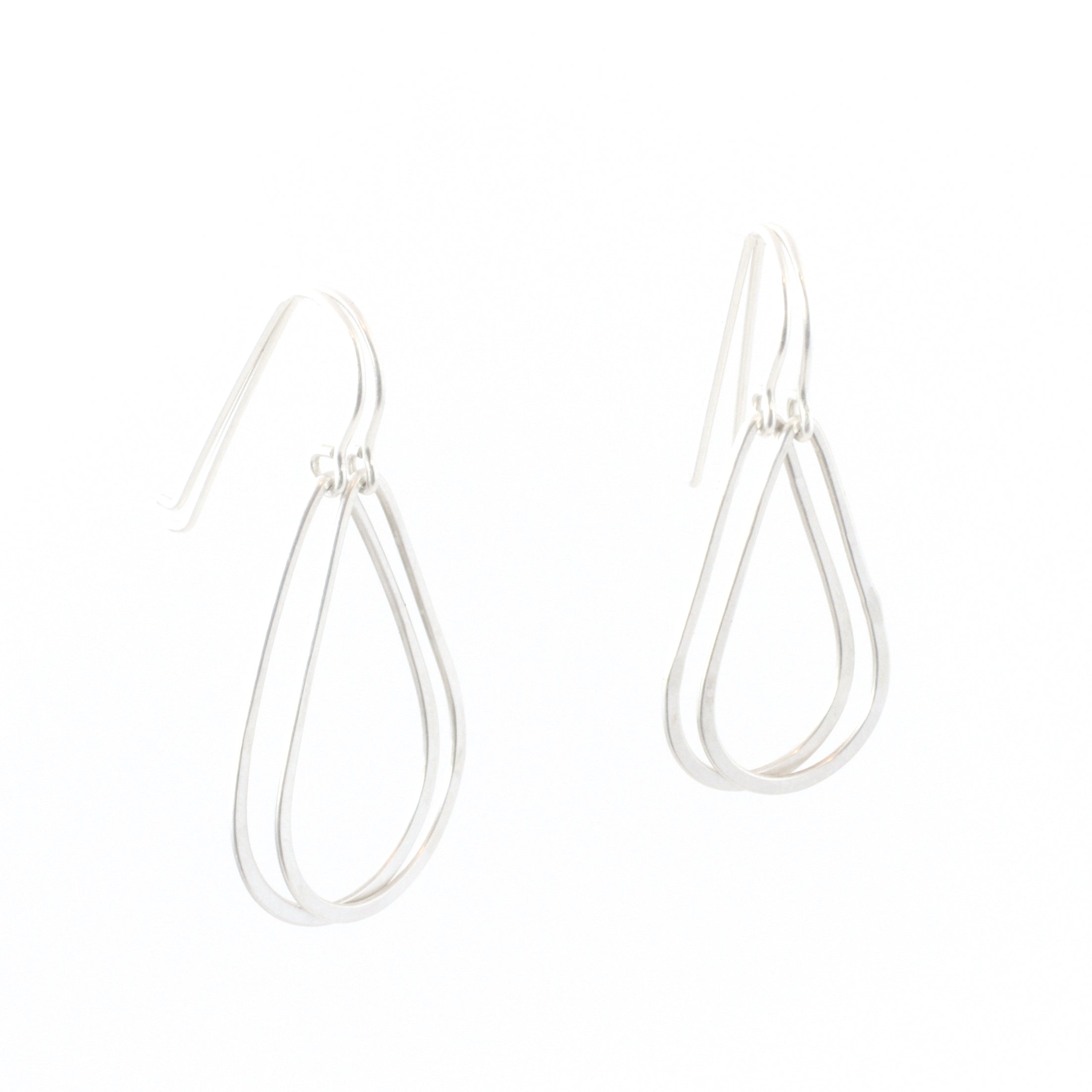 Small and large sizes of teardrop shaped earrings, hanging next to each other.